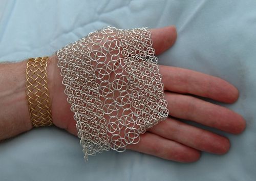 Two sizes of knotted chain mail knit together.